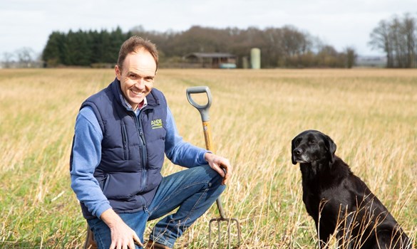 a man sitting in a field with a dog